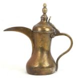 An Islamic brass dallah coffee pot with impressed mark and Saudi coat of arms, 29cm (11.5 ins) high.