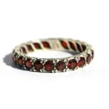 A 9ct white gold garnet set eternity ring, approx UK size 'P'.