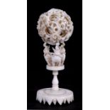 A late 19th / early 20th century Chinese ivory puzzle ball on stand, 11cms (4.25ins) high;