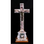 A mother of pearl and abalone shell decorated with a crucifix, 23cms (9ins) high.