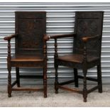 A pair of Victorian oak carver chairs with carved back panels, solid seat and turned front legs