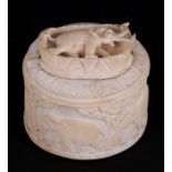 A early 20th century ivory oval lidded box decorated with elephants, 10cms (4ins) diameter.