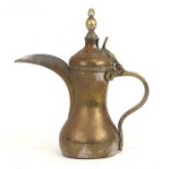 An Islamic brass dallah coffee pot with impressed mark and Saudi coats of arms.26cm (10.25 ins)