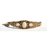 A late Victorian / Edwardian 9ct gold opal and ruby set bangle.Condition ReportOpals in good