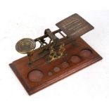 A Morden & Co. brass postal scales (lacking weights); together with a hand magnifier (2).