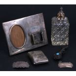 A silver desk top photo and calendar stand; together with a silver cigarette case; two silver bottle