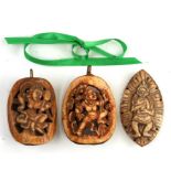 Three Indian carved bone pendants decorated with figures.