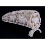 An early 20th century deeply carved ivory tusk tip depicting various animals including lions,