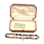 An Egyptian string of glass and stone beads with enclosed label reading 'Ancient Egyptian string