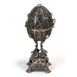 A Russian silver christening egg, the filigree egg opening to reveal a rampant lion standing on a