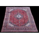 A Persian Kashan woollen hand knotted carpet with central floral medallion within floral borders, on
