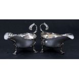 A pair of Victorian silver sauce boats with scroll handles and shell capped feet, London 1890,