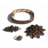 A Victorian suite of yellow metal garnet mounted jewellery to include a bangle, brooches and a