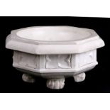 A pottery travelling font of octagonal form on four paw feet, 24cms (9.5ins) wide.Condition