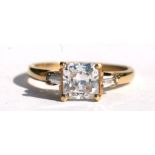 A 9ct gold ring set with a square white stone flanked by two baguette cut white stones, approx UK