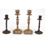 A pair of figural brass candlesticks, 20.5cms (8ins) high; together with another similar pair, 16cms