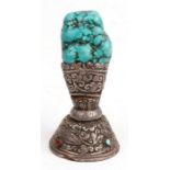 An Indian turquoise seal on a silver coloured metal base, 11cms (4.25ins) high.