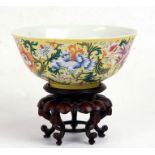 A Chinese famille rose bowl decorated with flowers on a yellow ground, blue seal mark to the