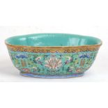 A Chinese famille rose shaped oval bowl decorated with flowers and characters on a turquoise ground,