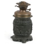 A Victorian spelter oil lamp decorated with cherubs, 29cms (11.5ins) high.