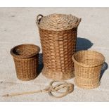 A wickerwork laundry basket, 66cms (26ins) high; together with two wastepaper baskets and a