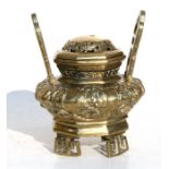 A Chinese polished bronze two-handled censer decorated with stylised dragons, 18cms (7ins) high.