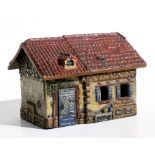 A Folk art painted wooden cottage, 20cms (8ins) wide.