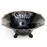 A black glass three-footed bowl with silvered inlay, 27cms (10.5ins) diameter.