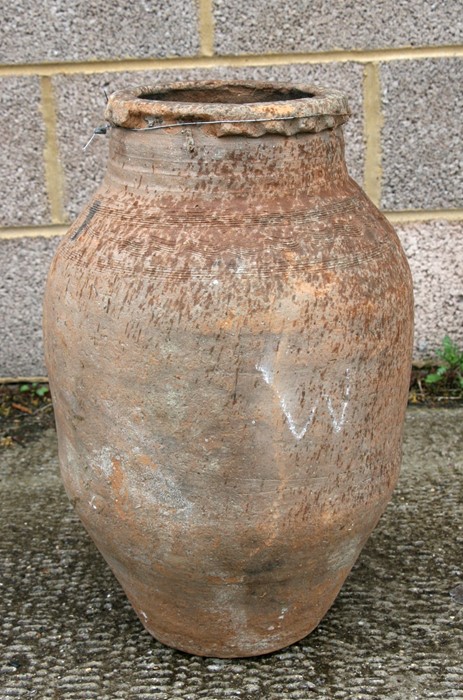 A terracotta olive jar of ovoid form, 50cms (20ins) high.