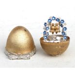 A silver gilt surprise egg by Christopher Lawrence which opens to reveal two love birds on a