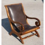 A Regency style mahogany armchair with scroll arms and leather seat.