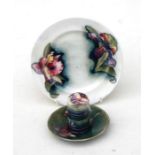 A W Moorcroft pottery plate decorated with flowers, signed, 17cms (6.75ins) diameter; together