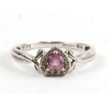 A 9ct white gold ring set with a central heart shaped pink stone surrounded by diamonds, approx UK