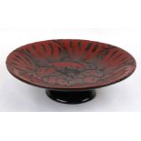 A Japanese red lacquer shallow bowl on stand with seventeen character mark to the underside,