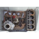 Assorted Austin 7 spares including a cylinder block, inlet manifold, and other items.