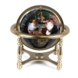 A semi precious stone set astragal globe on brass stand, 32cms (12.5ins) wide.