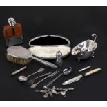A silver sauce boat, a silver mounted hip flask,a silver back brush, a silver charm bracelet and