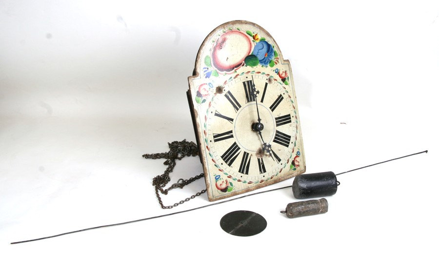 A wall clock, the 25cms square painted arched dial having Roman numerals and spandrels painted