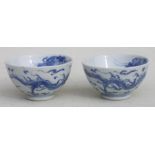 A pair of Chinese blue & white tea bowls, decorated with dragons chasing a flaming pearl, 7.5cms (