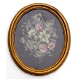An oval woolwork picture decorated with a floral spray, in a gilt frame, 38 by 48cms (15 by 19ins).