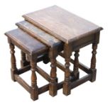 A nest of three joint stool oak tables with baluster turned legs, the largest 55cms (21.5ins) wide.