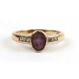 A 9ct gold ring set with a central oval amethyst and diamond set shoulders, approx UK size 'L'.