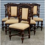 A set of six oak dining chairs with carved back rails, upholstered overstuffed seats, on carved