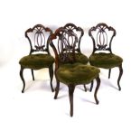A set of four Victorian rosewood dining chairs with upholstered seats, on cabriole front supports.