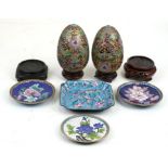 A pair of cloisonne eggs with hardwood stands, 15cms (6ins) high; together with three cloisonne