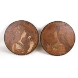 A pair of Art Nouveau pokerwork panels depicting maidens, 36cms (14ins) diameter (2).