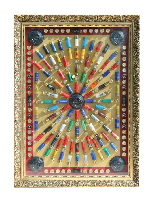 Shooting interest. A framed display of spent 12-bore cartridge cases, cartridge tops and clays, 70