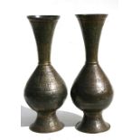 A pair of Persian brass vases decorated figures animals and calligraphy, 38cms (15ins) high.