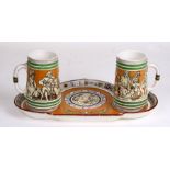 A pair of Minton pottery beer jugs and tray with the wording ' Ye Be Welcome With Outen Any Year