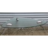 A contemporary coffee table with tear drop shaped glass top on aluminium legs, 110cms (43.5ins)